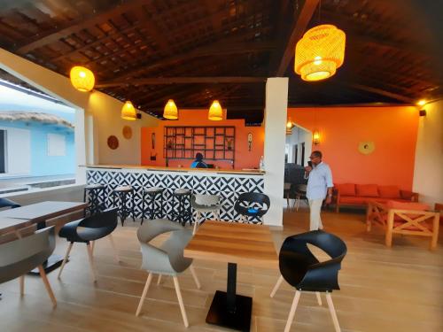 a man standing in a room with a table and chairs at Chalets Chomoni 