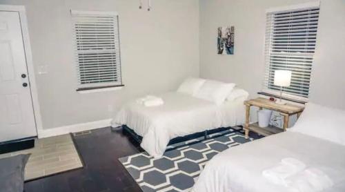 a bedroom with two beds and a table with a lamp at Housepitality - The Urban Roost 1 - Modern in Columbus