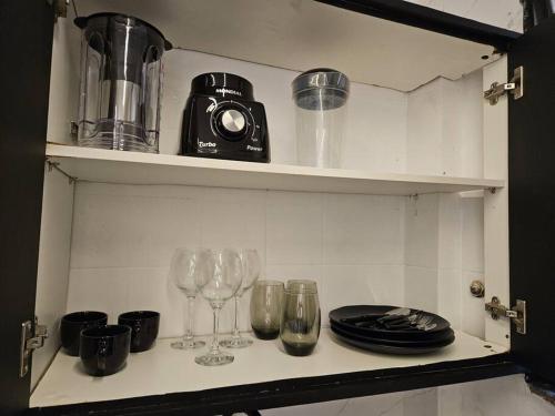 a kitchen shelf with wine glasses and a toaster at Apartamento 1 quarto em Copacabana in Rio de Janeiro