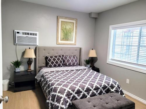 a bedroom with a bed with a black and white comforter at Nice and cozy whole house 25min to Niagara falls in Buffalo