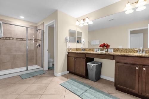 a bathroom with two sinks and a shower at Perfect Disney Holiday! Private Pool, Spa, Resort! in Kissimmee