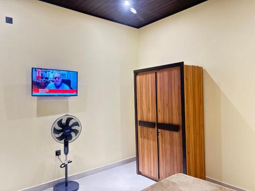 a room with a fan and a tv on the wall at New Haven Polonnaruwa in Polonnaruwa
