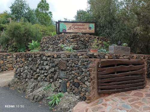 een stenen muur met een bord op de achtergrond bij HACIENDA LA CENTENARIA,CASAS RURALES in El Paso