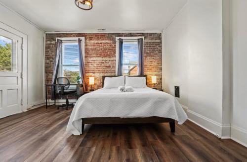ein Schlafzimmer mit einem Bett und einer Ziegelwand in der Unterkunft Housepitality - City View Loft - German Village in Columbus