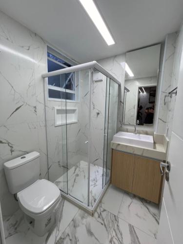 La salle de bains est pourvue de toilettes, d'un lavabo et d'un miroir. dans l'établissement MARAVILHOSO APARTAMENTO NO LEBLON, à Rio de Janeiro