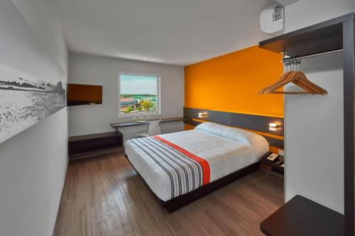 a hotel room with a bed and a window at City Express Junior by Marriott CDMX Sullivan in Mexico City