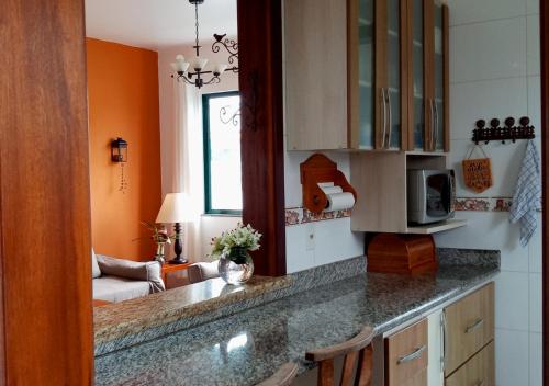 uma cozinha com paredes cor de laranja e uma bancada em Casa de Praia Penha, Beto Carrero, 500m da Praia da Armação em Penha