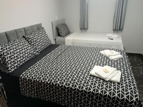 a bedroom with two beds with black and white sheets at Hotel RD in Rebouças