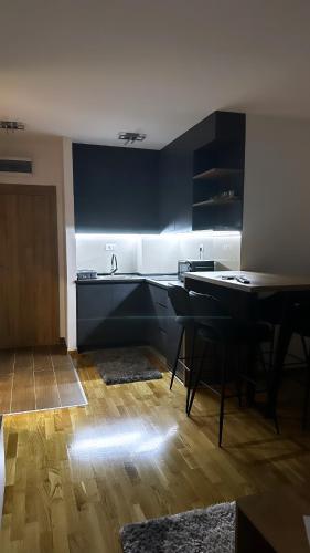 兹拉蒂博尔Silver Wolf SPA & relax的厨房配有黑色橱柜和桌椅