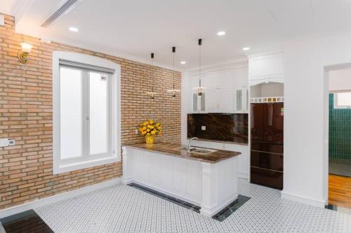 a kitchen with a sink and a brick wall at Đại Nam Villa in Buon Ma Thuot