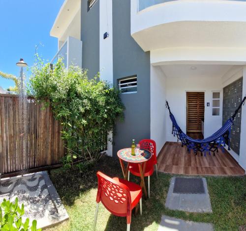 a backyard with a table and chairs and a hammock at MSFlats Paripueira Aconchegante, Moderno Praia Mansa in Paripueira