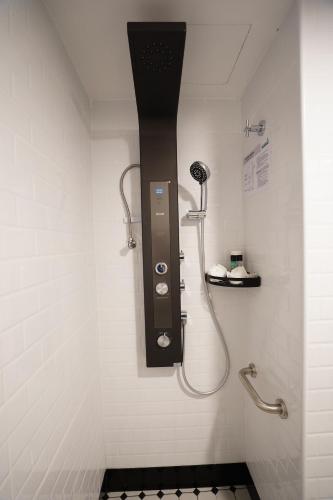a bathroom with a shower with a hair dryer on the wall at Dê MOCCIS Boutique Hotel in Kuala Lumpur