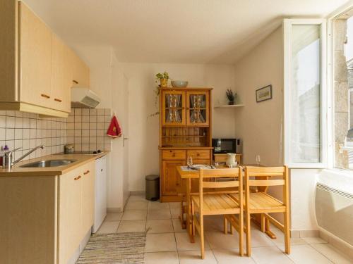 une cuisine avec une table, des chaises et un évier dans l'établissement Studio cosy à 300 m de la plage, cœur de La Turballe, tous commerces à pied - FR-1-306-901, à La Turballe