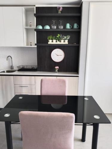 a kitchen with a black table and a pink chair at A pasos de la UDEC y centro in Concepción
