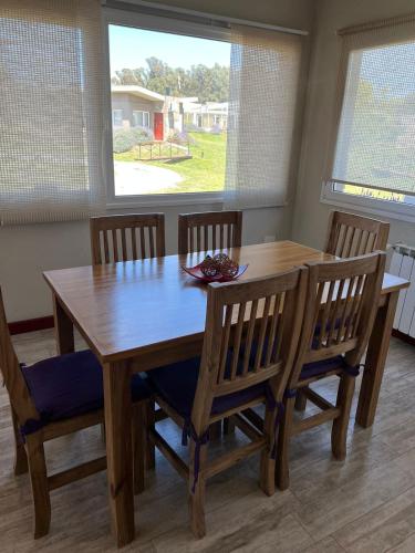 a dining room table and chairs with a table and a window at Tandil del Lago in Tandil