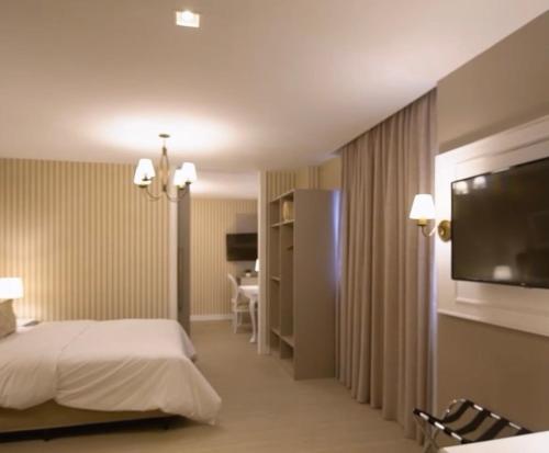 um quarto de hotel com uma cama e uma televisão de ecrã plano em Gramado Parks em Gramado
