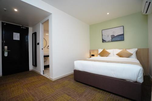 a bedroom with a large bed and a bathroom at Dê MOCCIS Boutique Hotel in Kuala Lumpur