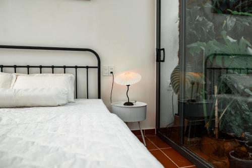 a bedroom with a bed and a lamp on a table at ngaunhien's house - Homestay in Thôn Dư Khánh
