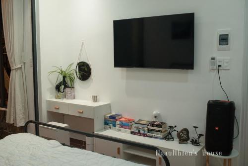 a bedroom with a tv hanging on the wall at ngaunhien's house - Homestay in Thôn Dư Khánh