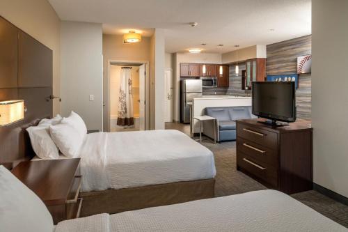 a hotel room with two beds and a flat screen tv at Residence Inn by Marriott Williamsport in Williamsport