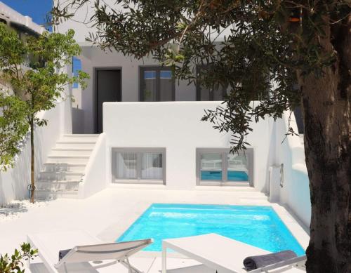 a pool with a table and chairs next to a house at Amy Villa , Agios Prokopis in Agios Prokopios