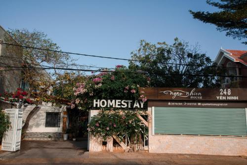 a house with a garage with a sign that reads homesatan at ngaunhien's house - Homestay in Thôn Dư Khánh