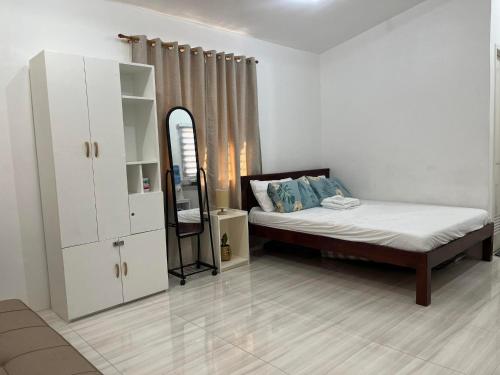 a bedroom with a bed and a dresser and a mirror at Bungalow House-Olango Island in Lapu Lapu City