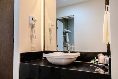 baño con lavabo blanco en la encimera en Hotel Gran Avenida, Navojoa en Navojoa