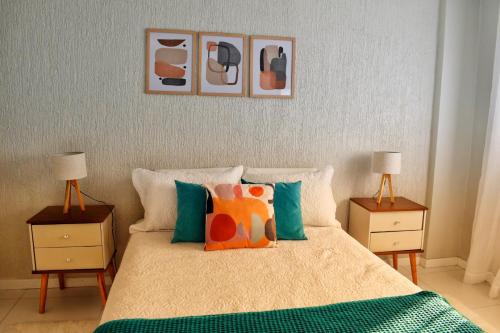 a bedroom with a bed with pillows and two lamps at Apartamento da Júlio in São Francisco de Paula