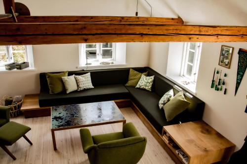 a living room with a couch and a table at The Mill House - Saeby Watermill in Sæby