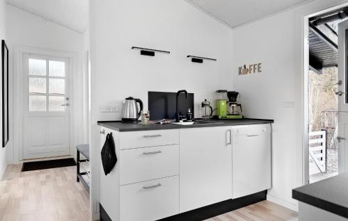a white kitchen with a sink and a counter at Beautiful Home In Dronningmølle in Dronningmølle