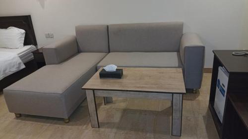 فندق سفير العرب في رفحاء: غرفة معيشة مع أريكة وطاولة