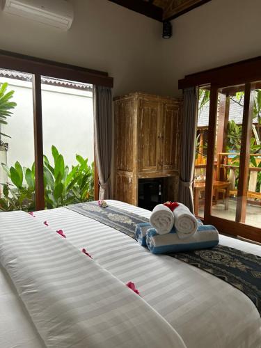 a bedroom with a bed with towels on it at Unzipp Bungalows Gili Air in Gili Islands