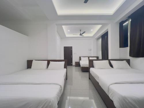 een kamer met 3 bedden en een plafond bij AROMA INN in Kalpatta