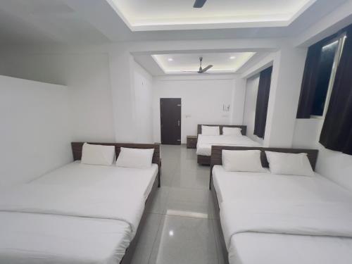 a room with three beds in a room at AROMA INN in Kalpetta