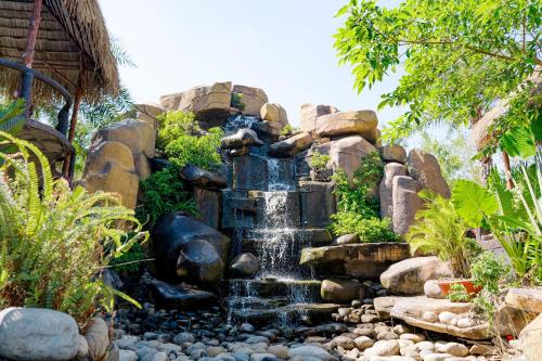 a waterfall in the middle of a garden at Charm Villas in Ba Ria