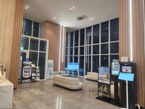 a lobby with couches and tables in a building at Sokcho Summitbay 1807 "Ocean View" in Sokcho