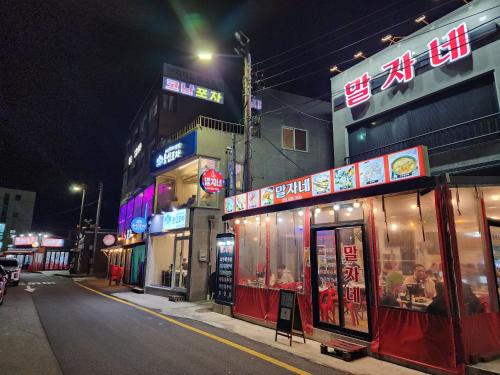 a city street at night with signs on buildings at Sokcho Summitbay 1807 "Ocean View" in Sokcho