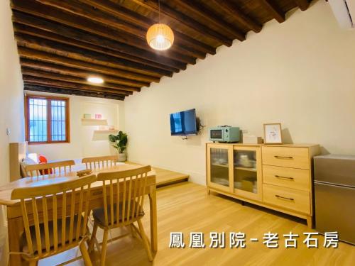 a kitchen with a table and a dining room at 捉鳳凰 台南百年老宅包棟導覽民宿系列Catchphoenix Centennial Guesthouse in Tainan