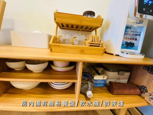 una estantería de madera con cuencos y otros artículos. en 捉鳳凰 台南百年老宅包棟導覽民宿系列Catchphoenix Centennial Guesthouse en Tainan