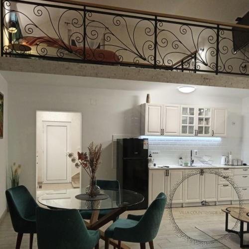 a kitchen with a table and some chairs and a kitchen with a counter at Villa Countryside Vrsac in Vršac
