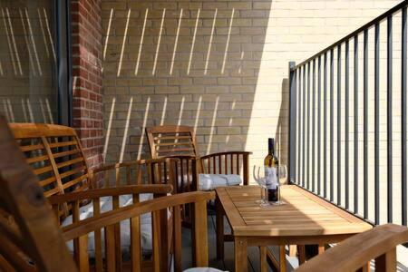una mesa de madera con una botella de vino en el balcón en Modern one Bedroom Apartment in Ealing Common en Londres