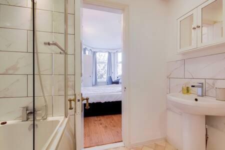 y baño con lavabo, aseo y ducha. en Spacious Apartment In The Heart Of Ealing Broadway en Londres