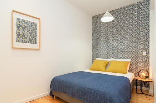 a bedroom with a bed and a blue and white wall at Arroios Concept Apartments by Homing in Lisbon