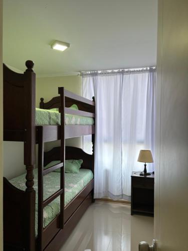 1 dormitorio con 2 literas y ventana en Imagine Apartment, en Lima