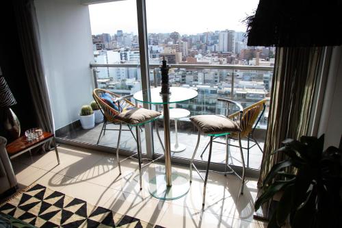 a table and chairs in a room with a window at Chic Miraflores AC HEATER 16th floor in Lima