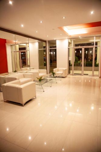 a living room with white couches and tables and windows at Chic Miraflores AC HEATER 16th floor in Lima