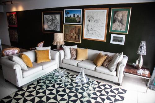 a living room with two couches and pictures on the wall at Chic Miraflores AC HEATER 16th floor in Lima