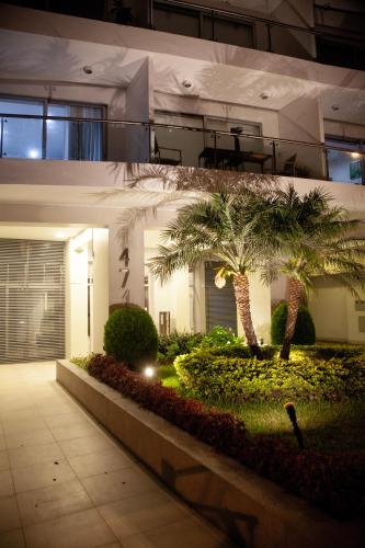 a building with palm trees in front of it at Chic Miraflores AC HEATER 16th floor in Lima