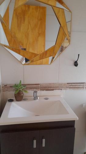 W łazience znajduje się umywalka i lustro. w obiekcie Puesta del Sol Apart w mieście Puerto Iguazú